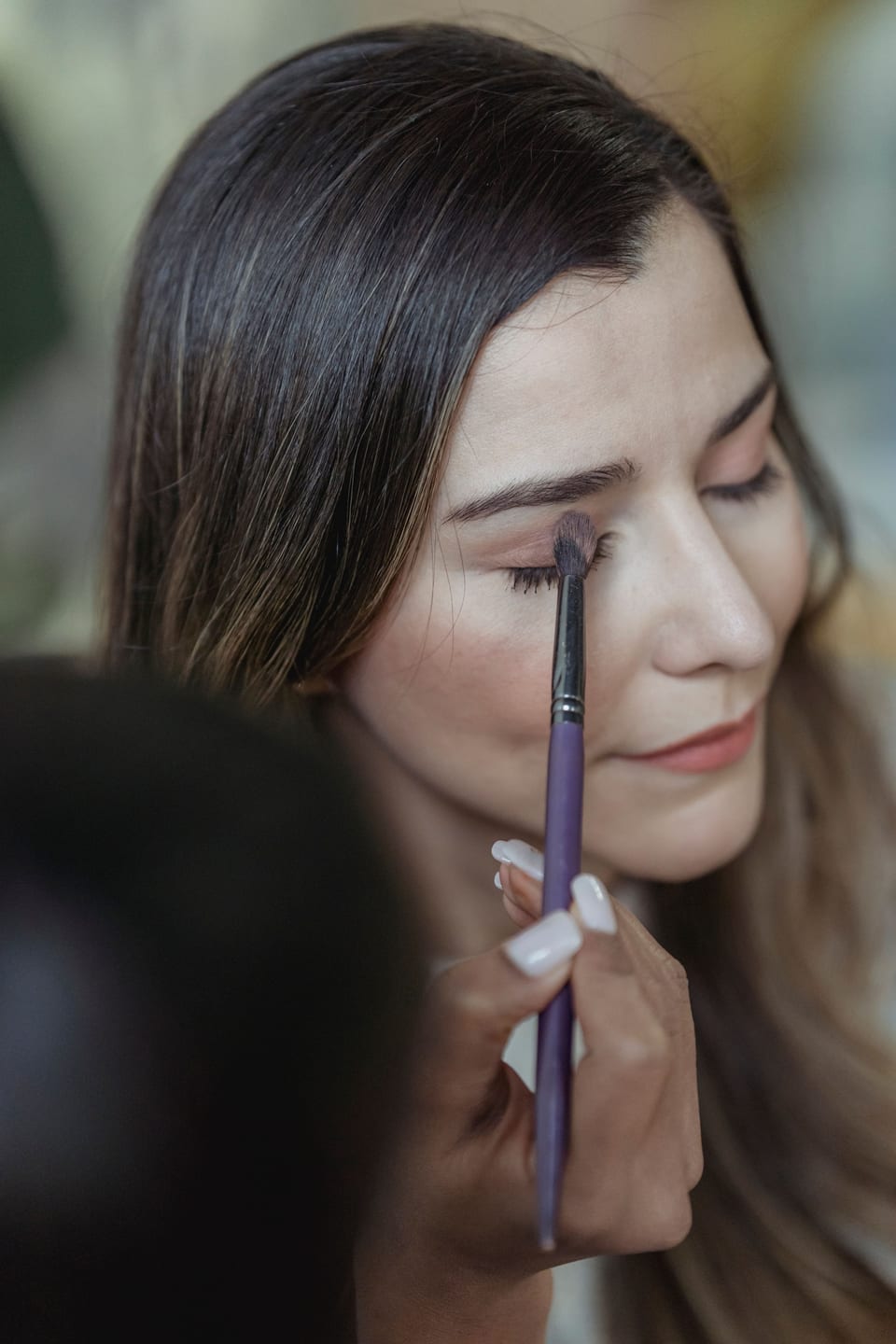 Makeup appliceras med pensel på en kund.